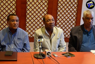 Minister of Tourism, Hon. Edmund Bartlett (centre), addresses journalists at a tourism stakeholder press conference at the Montego Bay Convention Centre in Rose Hall, St. James, on July 4. He is flanked by Director of Tourism, Paul Pennicook (left); and Chairman of the Jamaica Tourist Board (JTB) John Lynch.