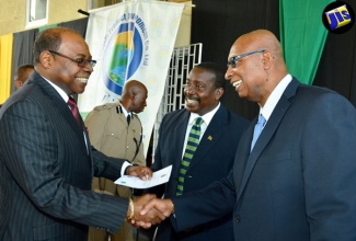 Minister of Tourism, Hon. Edmund Bartlett (left) is greeted by Acting Commissioner of Police, Glenmore Hinds (right), as he arrives at the National Police College of Jamaica in Twickenham Park, St. Catherine, on Tuesday (July 19) to participate in the closing ceremony for the Tourism Safety and Security District Constables Training Programme. Also pictured is Minister of National Security, Hon. Robert Montague. During the ceremony, certificates were presented to the first batch of 89 district constables, who have been trained to serve in the island’s resort areas.