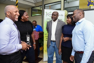 Senior Advisor in the Science, Energy and Technology Ministry, Trevor Forrest (centre), along with (from left) Sales Manager of Brands for IBM Caribbean, Pat Tomlinson; Client Manager of IBM World Trade Corporation Jamaica, Leona Atkins; Innovation Advisor of IBM World Trade Corporation Jamaica, Dr. Kala Fleming; and eGov Jamaica Limited, Chief Executive Officer (CEO), Maurice Barnes. at the eGov Jamaica Limited Hackathon at the agency’s Old Hope Road offices in St. Andrew on February 15. 