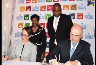 Minister of Foreign Affairs and Foreign Trade, Senator the Hon. Kamina Johnson Smith (left) and United Nations Resident Coordinator, Bruno Pouezat sign an agreement for the UN Multi-Country Sustainable Development Framework (UNMSDF) in Jamaica, at the Spanish Court Hotel in St. Andrew, today (January 19). Others looking on are: Permanent Secretary in the Ministry, Ambassador Marcia Gilbert Roberts and Director General, Planning Institute of Jamaica, Dr. Wayne Henry.