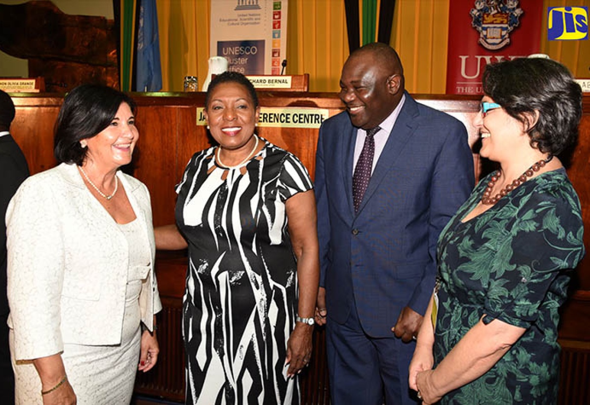 Minister of Culture, Gender, Entertainment and Sport, Hon. Olivia Grange (second left), shares pleasantries with (from left) President, International Federation of Library Associations and Institutions, Gloria Pérez-Salmerón; Executive Director, Broadcasting Commission of Jamaica and Chairman for the Information Advisory Committee, Jamaica National Commission for UNESCO, Cordel Green; and Chair, International Conference on Media and Information Literacy and Intercultural Dialogue, (MILID), Esther Hamburger, during the opening ceremony of the Global Media and Information Literacy conference at the Jamaica Conference Centre in downtown Kingston on October 25. 