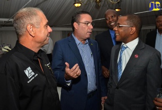 Minister without Portfolio in the Ministry of Economic Growth and Job Creation, Hon. Daryl Vaz (second left), in conversation with CEO of AVS Builders Limited, Arthur Von Strolley (left); and President and CEO of Victoria Mutual Building Society (VMBS), Courtney Campbell (right), during the launch of 20 South, a high-rise real-estate development on South Avenue in St. Andrew, at the Terra Nova All Suite Hotel on February 23. Looking on are CEO of VMBS Wealth Management, Devon Barrett (second right, background) and Managing Director, ATL Retail, Danville Walker (right, background). The 20 South development, being done by AVS Builders, will be completed in March 2018.