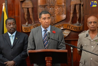 Prime Minister, the Most Hon. Andrew Holness (centre), addresses a press briefing at Jamaica House on Tuesday (October 17), where he declared Denham Town the second Zone of Special Operations (ZOSO). Others (from left) are Minister of National Security, Hon. Robert Montague; and Commissioner of Police, George Quallo.