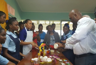 Minister of Science, Energy and Technology, Dr. the Hon. Andrew Wheatley (right), samples a coconut body butter made by students and teachers of the Sydney Pagon Science Technology Engineering and Mathematics (STEM) Academy in St. Elizabeth. Occasion was the school’s STEM Projects and Career Day held on May 31 under the theme: ‘STEM: Fuelling 21st Century Innovations, Economic Growth and Development.’