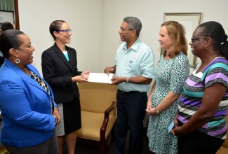 Minister of Foreign Affairs and Foreign Trade, Senator the Hon. Kamina Johnson Smith (second left),  presents a cheque, from the Washington Mission, to the Board Chairman of the Wortley Home for Girls, Raphael Sangster (third right), to assist in the rebuilding of the Home. The presentation took place today (November 11) at the Ministry of Foreign Affairs and Foreign Trade, Dominica Drive, Kingston. Others (from left) are Chief Executive Officer of the Child Development Agency, Rosalee Gage Grey; Board member, Wortley Home for Girls, Tanya Wildish and House Mother of the Wortley Home for Girls, Deloris Bailey.