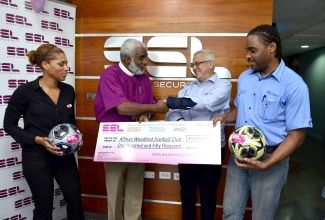 Minister of Education and Member of Parliament for Central Kingston, Hon. Rev. Ronald Thwaites (2nd right), shakes hands with Chairman of  Stocks and Securities Limited (SSL) Foundation, Bishop Robert Thompson (2nd left), during the handing over of a cheque valued at $150,000 to Vice President of the Allman/Woodford Football Club, Errol Howlett (right). The presentation was made on August 14, at the SSL’s Hope Road office. General Manager of SSL, Lamar Harris (left), shares the moment.