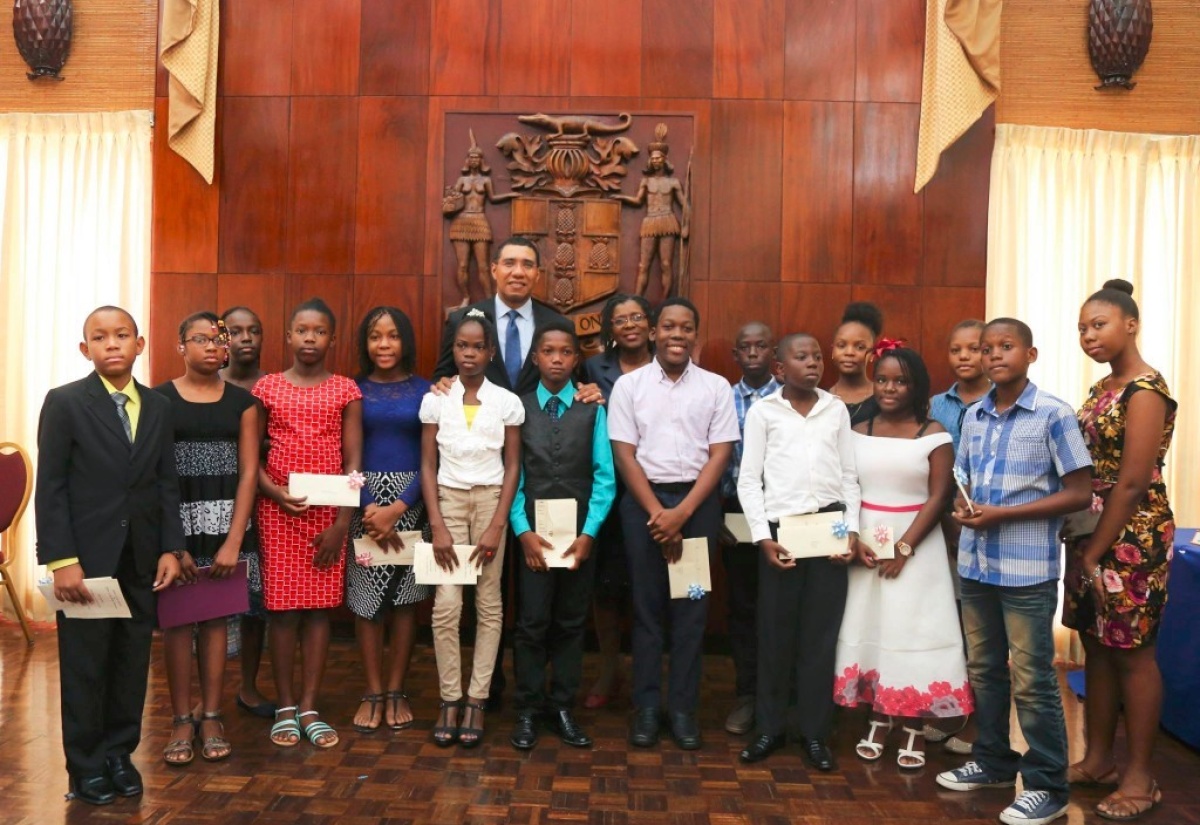 Prime Minister Andrew Holness shares a photo opportunity with students of staff members at the Office of the Prime Minister. The students who sat the Grade Six Achievement Test this year were honoured by the Prime Minister during a special ceremony on Wednesday, August 23 at Jamaica House. Also sharing in the moment is Mrs Audrey Sewell, Permanent Secretary in the Office of the Prime Minister.  