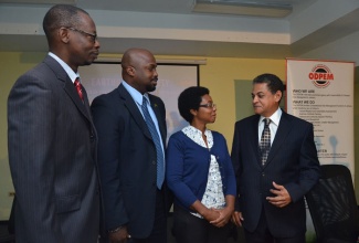 Minister of Local Government and Community Development, Hon. Noel Arscott (right), in discussion with (from left): Chief Planner at the Urban Development Corporation, Ronald Brown; Director General of the Office of Disaster Preparedness and Emergency Management (ODPEM), Richard Thompson; and Scientific Officer at the Earthquake Unit, University of the West Indies, Mona, Karleen Black. Occasion was the press conference and launch of Earthquake Awareness Week 2014, at the Haining Road headquarters of the ODPEM, on January 13.