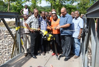  Minister of State in the Ministry of Transport, Works and Housing, Hon. Richard Azan (5th left), who is also Member of Parliament for North West Clarendon, cuts the ribbon to officially open the Southwood Bridge, in the Parish on November 29.  Others (from left) are:  Councillor for the Thompson Town Division, Kevin Shirley; Chief Executive Officer of the National Works Agency (NWA), E.G. Hunter; Councillor for the Frankfield Division, Orville Hackett; and community leader, Karen Carty. The bridge was constructed at a cost of $24 million. 