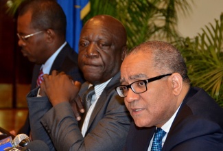 Bank of Jamaica (BoJ) Governor, Brian Wynter, addresses journalists during Tuesday’s (Nov. 19) quarterly media briefing at the BoJ’s downtown Kingston offices. Listening at left is Deputy Governors, John Robinson.