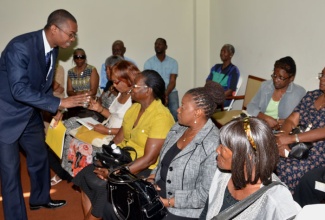 State Minister for Foreign Affairs and Foreign Trade, Hon. Arnaldo Brown (left), greets resettled residents and other persons attending Monday’s (January 12) launch of the Jamaica Association for the Resettlement of Returning Residents (JARRR) revamped website, at the Jamaica Conference Centre, downtown Kingston. Mr. Brown, who has responsibility for Diaspora Affairs,  was the guest speaker.