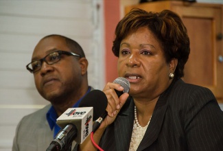 Director of the Regulatory Division at the Bureau of Standards Jamaica (BSJ), Orine Henry, addresses a press conference held at the agency’s Winchester Road offices today (December 16). A left is Head of the Standards Compliance Inspectorate, Regulatory Division, BSJ, Wendell Richards. 