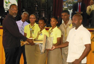 Students of the Anchovy High School, in St. James,  are joined by their Agricultural Science Teacher, Sean Thomas (right), in collecting a set of gardening tools from Minister of State in the Ministry of Agriculture and Fisheries and Labour and Social Security, Hon. Luther Buchanan (left). Joining in the presentation, which took place on World Food Day,  October 15,  Dr. Jerome Thomas (second left), representing the Food and Agriculture Organization (FAO) in Jamaica, the Bahamas and Belize. 