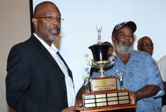 Champion cane farmer from the Clarendon Cane Farmers Association, Raphael Robotham (right), receives his winning trophy from Minister of State for Agriculture, Labour, and Social Security, Hon. Luther Buchanan, during the awards segment of the annual general meeting of the All-Island Jamaica Cane Farmers’ Association held at the Jamaica Pegasus Hotel in Kingston on Thursday, November 6.