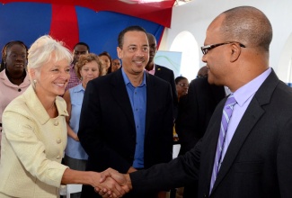 Minister of National Security, Hon. Peter Bunting (right), is greeted by President and Chief Executive Officer (CEO), Jamaica Public Service (JPS), Kelly Tomblin on his arrival at the company’s Sports Club in Kingston for the official signing of a partnership agreement, through which  20 youth from the Citizen Security and Justice Programme (CSJP) will  receive on the job training at the JPS over a six-month period. The signing took place at the company’s Sports Club, in Kingston, on February 6. At centre is Senior Vice President, JPS, Gary Barrow.  