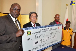 Minister of Education, Youth and Information (left), Senator the Hon. Ruel Reid (left); Japan’s Ambassador to Jamaica, His Excellency Masanori Nakano (second left); Principal, Epworth Primary School, Kirk Spencer;  and student, Epworth Primary School, Samuel Henry, display a symbolic cheque during a signing ceremony at the Ambassador’s Paddington Terrace residence in St. Andrew on March 30. The $10 million (US$82,715) to the institution will be used to construct two additional classrooms.   The money has been provided under the Japanese Government’s Grant Assistance for Grassroots Human Security Projects and initiated through a partnership forged between the National Education Trust (NET) and the Japanese Embassy in Jamaica.