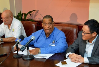 Minister of Agriculture and Fisheries, Hon. Roger Clarke (centre), addresses the signing ceremony for an agreement between the All Island Jamaica Cane Farmers Association and Pan-Caribbean Sugar Company to authorise the sale of sugar and molasses, and establish a pricing regime. The ceremony was held on January 15 at the Ministry’s Hope Gardens offices. Also participating are: Chairman of the All Island Jamaica Cane Farmers’ Association, Allan Rickards (left) and Chief Executive Officer (CEO) of Pan-Caribbean, Dr. Huaixiang Wu.