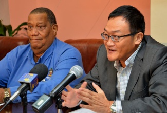 Agriculture and Fisheries Minister, Hon. Roger Clarke (left), looks on as Chief Executive Officer (CEO) of Pan-Caribbean, Dr. Huaixiang Wu, addresses the signing of an agreement between the All Island Jamaica Cane Farmers Association and Pan-Caribbean Sugar Company to authorise the sale of sugar and molasses, and establish a pricing regime. The ceremony was held on January 15 at the Ministry’s Hope Gardens offices.