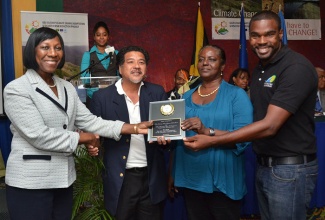 Director Policy, Planning , Evaluation and Research at the National Environment and Planning Agency (NEPA), Novelette Douglas (left), presents the award for Most Improved Project Implementer to representatives of the Montego Bay Marine Park Trust/Montego Bay Fisherman’s Cooperative Society Limited. They are (from second left), Executive Director,  Montego Bay Marine Park Trust, Hugh Shim; Board Member, Montego Bay Fisherman’s Co-Operative, Janet Fletcher; and Project Coordinator, Joshua Bailey. Occasion was a Closure and Awards Ceremony for the project at the Knutsford Court Hotel in Kingston, on December 10.