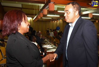 Health Minister, Dr. the Hon. Christopher Tufton (right), greets Registered Nurse and Chairperson of the Jamaica Diaspora Health Sector, Claudette Powell, at a special Diaspora interest group meeting, held at the Jamaica Diaspora Conference in downtown Kingston on July 26. 