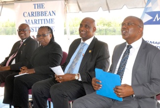 Minister without Portfolio in the Ministry of Transport, Works and Housing, Hon. Dr. Morais Guy (right), enjoys a light moment at the opening of the Caribbean Maritime Institute’s (CMI) two-day open day and exhibition on Monday (Sept. 21). Others (from left) are: CMI Chaplain, Pastor Linton Williams; Deputy Executive Director CMI, Vivette Grant; and Executive Director,  Dr. Fritz Pinnock. Dr. Guy delivered the keynote address at the function, which was among events to mark Maritime Awareness Week from September 20-26.