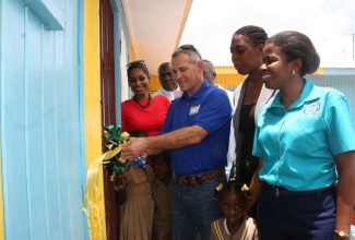 Minister of Youth and Culture, and Member of Parliament for St. Ann South Eastern, Hon. Lisa Hanna (2nd left), looks on as President of the Levitetz Family Foundation, Jeff Levitetz (3rd right), cuts the ribbon to officially open the new Steerfield Basic School in St. Ann on Wednesday, May 15. Others sharing the moment are (from left); Food For the Poor board member, Rev. Father Burchell McPherson; Principal of the school, Mitsie Richards; Regional Director, Ministry of Education Region 3, Maxine Headlam; and students of the school.