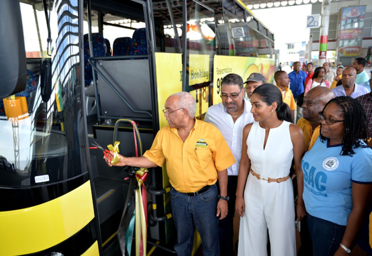 Minister of Transport, Works and Housing, Dr. the Hon. Omar Davies (left), cuts the ribbon to launch the Jamaica Urban Transit Company (JUTC) Kingston City Tours, at the Half-Way-Tree Transport Centre, on Saturday, August 1. Looking on  (from second left) are:  Minister of Tourism and Entertainment, Hon. Dr. Wykeham McNeill; Minister of Youth and Culture, Hon. Lisa Hanna;  Managing Director of the JUTC, Mr. Colin Campbell and Mayor of Kingston, Senator Councillor, Dr. Angela Brown-Burke. 