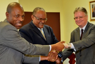 Permanent Secretary in the Ministry of National Security, Major General (Retired) Stewart Saunders (centre); shakes hands with British High Commissioner, His Excellency David Fitton (right); and Deputy Commissioner of Police with responsibility for the crime, Carl Williams, after the signing of a Memorandum of Understanding (MoU), aimed at strengthening the monitoring and management of deportees. The signing ceremony was held on December 13, at the Ministry in Kingston.