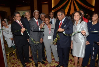 Minister of Foreign Affairs and Foreign Trade, Senator  the Hon. A.J. Nicholson (2nd left), cuts the ribbon to open the Diaspora  Marketplace, a new feature at the 5th Biennial Jamaica Diaspora Conference 2013, which is currently underway at the Montego Bay Convention Centre in St. James.  Assisting Senator Nicholson (from right) are: State Minister in the Ministry of Industry, Investment and Commerce, Hon. Sharon Ffolkes Abrahams;  Minister of Industry, Investment and Commerce, Hon Anthony Hylton; Conference Co-ordinator, Lisa O’Gilvie and Chairman of the Jamaica Diaspora Conference Preparatory Committee, Mr. Richard Powell.
