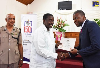 Minister of National Security, Hon. Robert Montague (centre), presents Pastor Mikhail Solomon (right) with a certificate during the Domestic Violence Intervention Training Workshop closing ceremony held on August 22 at the Andrews Memorial Seventh-day Adventist Church in Kingston. At left is the Commissioner of Police, George Quallo. More than 200 volunteer pastors and Jamaica Constabulary Force (JCF) Peer Counsellors were trained in Domestic Violence Intervention.