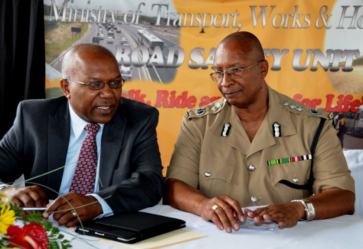 Minister without Portfolio, Ministry of Transport, Works and Housing, Hon. Dr. Morais Guy (left), converses with Deputy Commissioner of Police,  Glenmore Hinds, at the launch of the Ministry’s three-month islandwide road safety campaign, at the Half-Way Tree transport centre, on September 27.  The campaign is being staged under the theme: ‘Walk, Ride, and Drive for Life’.
