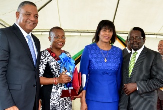 Prime Minister the Most Hon. Portia Simpson Miller (2nd right), Minister without portfolio with responsibility for Public Service, Hon. Horace Dalley (left) and Member of Parliament, Pearnel Charles representing the Opposition Leader shares a proud moment with long serving employee of the Jamaica Information Service, Enthrose Campbell who was awarded the 2013 Civil Servant of the Year. Two hundred and fifty three civil servants were recognized for their longstanding service and invaluable contribution to the development of the nation at an Award ceremony at Kings House on Wednesday (November 20). The Jamaica Civil Service Long Service Awards is part of Civil Service Week 2013 which is being celebrated from November 17 to 22. 