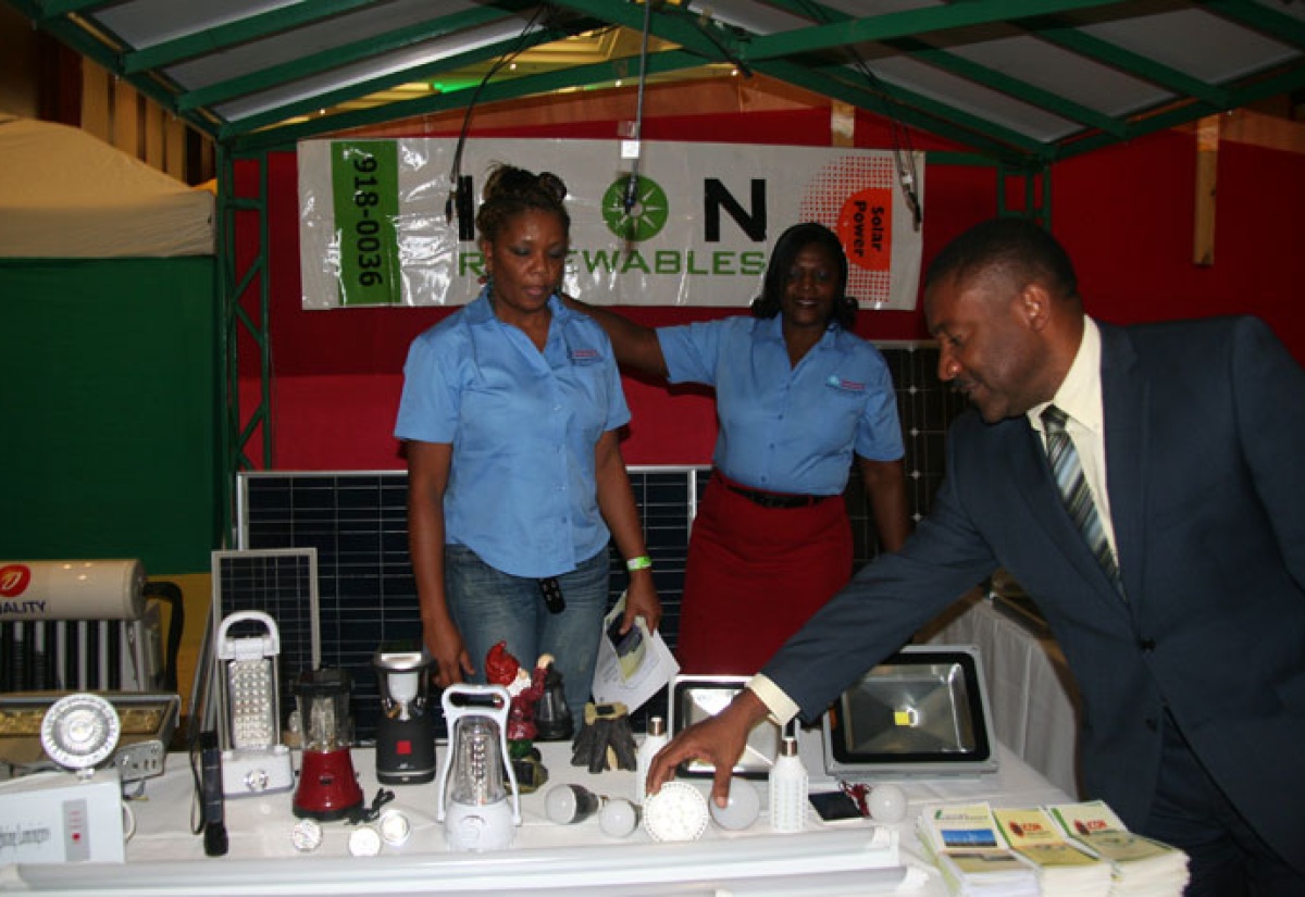 Minister of Science, Technology, Energy and Mining, Hon. Phillip Paulwell (right), inspects energy saving devices at the Jamaica Alternative Energy Conference and Expo,  held at the Montego Bay Convention Centre, in Rose Hall, St. James on September 20.