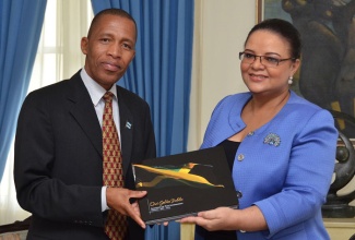 Minister with responsibility for Information, Senator the Hon. Sandrea Falconer presents Deputy Permanent Secretary, Ministry of State President, Botswana, Mogomotsi Kaboeamodimo with a copy of the JIS commemorative photo book, ‘Our Golden Jubilee’ at the Office of the Prime Minister on Wednesday, September 18. A delegation from Bostwana is in the island on a benchmarking exercise with the Jamaica Information Service.