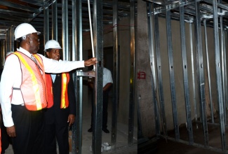 Minister of Health, Dr. the Hon. Fenton Ferguson (right), and Chairman of the South East Regional Health Authority, Lyttleton Shirley, tour the construction site of the new cardiac wing for the Bustamante Hospital for Children on Friday, December 13. 