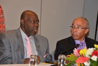 Minister of Health, Hon. Dr. Fenton Ferguson (left), makes a comment to Chairman of the National Health Fun (NHF), Sterling Soares, during opening of the 8th Caribbean Conference on Health Financing Initiatives at the Hilton Rose Hall Resort and Spa in Montego Bay on Tuesday, November 12.