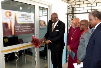 Minister of Health, Hon. Dr. Fenton Ferguson (left), cuts the ribbon to symbolize the official re-opening of the Accident and Emergency Unit at the Nuttall Memorial Hospital in St. Andrew during a ceremony February 19. Sharing in the moment (from right) are: Chairman of the hospital, Dr. Vincent Lawrence; Chief Executive Officer, Value Added Services  Limited, Fabian Brown; and Lord Bishop of Jamaica and The Cayman Islands, Rt. Rev. Dr. Howard Gregory.  (FILE)