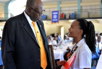 Minister of Health, Hon. Dr. Fenton Ferguson (left), converses with Head Girl, Ardenne High School, Ashleigh Paige Beersingh, at the institution’s distinguished lecture series 2014, on November 5. 