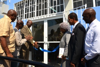 Minister of Health, Hon. Dr. Fenton Ferguson (third left), cuts the ribbon symbolically the official reopening of the Charles Chin Loy Health Centre in Western Kingston on November 28. Others from left are: Councillor, Tivoli Gardens Division, Donovan Samuels; Member of Parliament, Western Kingston, Desmond McKenzie; Project Manager, Culture, Health, Arts, Sports and Education (CHASE) Fund, Paulette Mitchell; Board Chairman, South East Regional Health Authority (SERHA), Lyttleton Shirley; Regional Director, SERHA, Donald Farquharson.