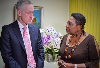 The Minister of Culture, Gender, Entertainment and Sport, the Honourable Olivia Grange (right) listens to a point being made by the Director of Standards and Harmonisation at the World Anti-Doping Agency, Tim Ricketts, during a meeting at her New Kingston office.