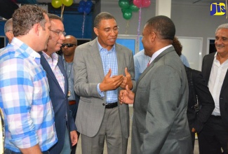 Prime Minister, the Most Hon. Andrew Holness (third left), has a light moment with Opposition Spokesperson on Mining and Energy, Phillip Paulwell (fourth left) at itelbpo’s fifth anniversary celebrations and grand opening of its facility in Freeport, St. James, on October 4. Others sharing the moment (from left) are itelbpo's Chief Executive Officer, Yoni Epstein; Minister without Portfolio in the Ministry of Economic Growth and Job Creation, Hon. Daryl Vaz; Attorney General, Marlene Malahoo Forte; and businessman Richard Lake.