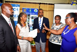 Chief Technical Director in the Ministry of Economic Growth and Job Creation, Lt. Col. Oral Khan (centre), listens to a point being made by Principal Director of the Climate Change Division in the Ministry, Una May Gordon (right), during a climate change gender analysis forum at the Alhambra Inn in Kingston on September 12. The forum was organised by the Ministry in tandem with the Friedrich-Ebert-Stiftung (Foundation for Social Democracy – FES) in Germany, and the South Centre in Switzerland. Others (from left) are Deputy Director General, Office of Disaster Preparedness and Emergency Management, Richard Thompson; gender activist and FES Consultant, Judith Wedderburn; and Senior Research Fellow, the South Centre, Mariama Williams.