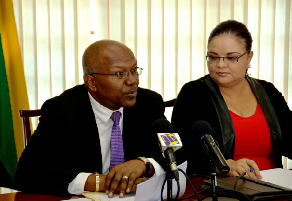 Minister without Portfolio in the Ministry of Transport, Works and Housing,  Hon. Dr. Morais Guy (left), announces that a new legislation to empower the Administrator General to transfer property to secondary beneficiaries, in now before Parliament. Occasion  was a Jamaica House media briefing in Montego bay on February 5. At right is Minister with responsibility for Information, Senator the Hon. Sandrea Falconer.