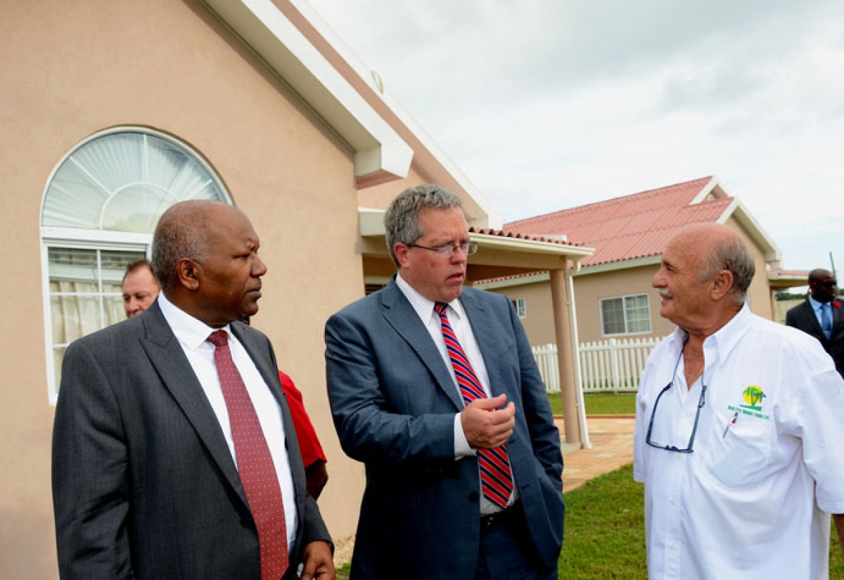Minister with responsibility  for Housing in the  Ministry of Transport, Works and Housing, Hon. Dr. Morais Guy (left); and New Era Homes 2000 Limited President, Benedetto Persichilli (right), listen to a point being emphasized by Canada’s High Commissioner to Jamaica, His Excellency Robert Ready,  following Wednesday’s (October 23) official opening of the Caymanas Country Club Estate housing development in St. Catherine. Dr. Guy was the main speaker. Phase one of the development, being undertaken by New Era Homes, comprises 264 one and two bedroom units, which have been completed, while the second phase, currently under construction, will provide an additional 420 units.