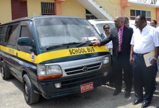 Minister without Portfolio in the Ministry of Transport, Works and Housing, Hon. Dr. Morais Guy (second right), admires one of the buses that will be used to transport students under the just launched School Transport Programme. Alongside the Minister is Chairman of the Transport Authority, Norton Hinds. The initiative was launched on September 18 at the Waterford Seventh Day Adventist Church in Portmore, St. Catherine. The programme is a partnership between the Transport Authority and the St. Catherine School Bus Association. 