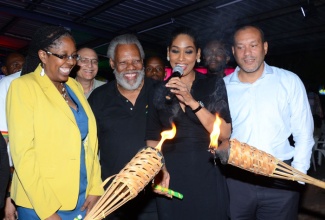 Youth and Culture Minister, Hon. Lisa Hanna (2nd right), performs the symbolic lighting of two torches to  launch Reggae Month 2014 at the Louise Bennett Garden Theatre, Hope Road, St. Andrew, on January 28. This year’s fifth celebration, organized by the Jamaica Reggae Industry Association (JaRIA), is being held throughout February under the theme: ‘The Journey Continues…’ Sharing the occasion (from left) are: Kingston’s Mayor,  Her Worship Senator Councillor Angela Brown Burke; Chairman, JaRIA, Michael ‘Ibo’ Cooper;  and Deputy Director of Tourism – Attractions, Cruise and Events at co-sponsor, the Jamaica Tourist Board (JTB), Jason Hall.