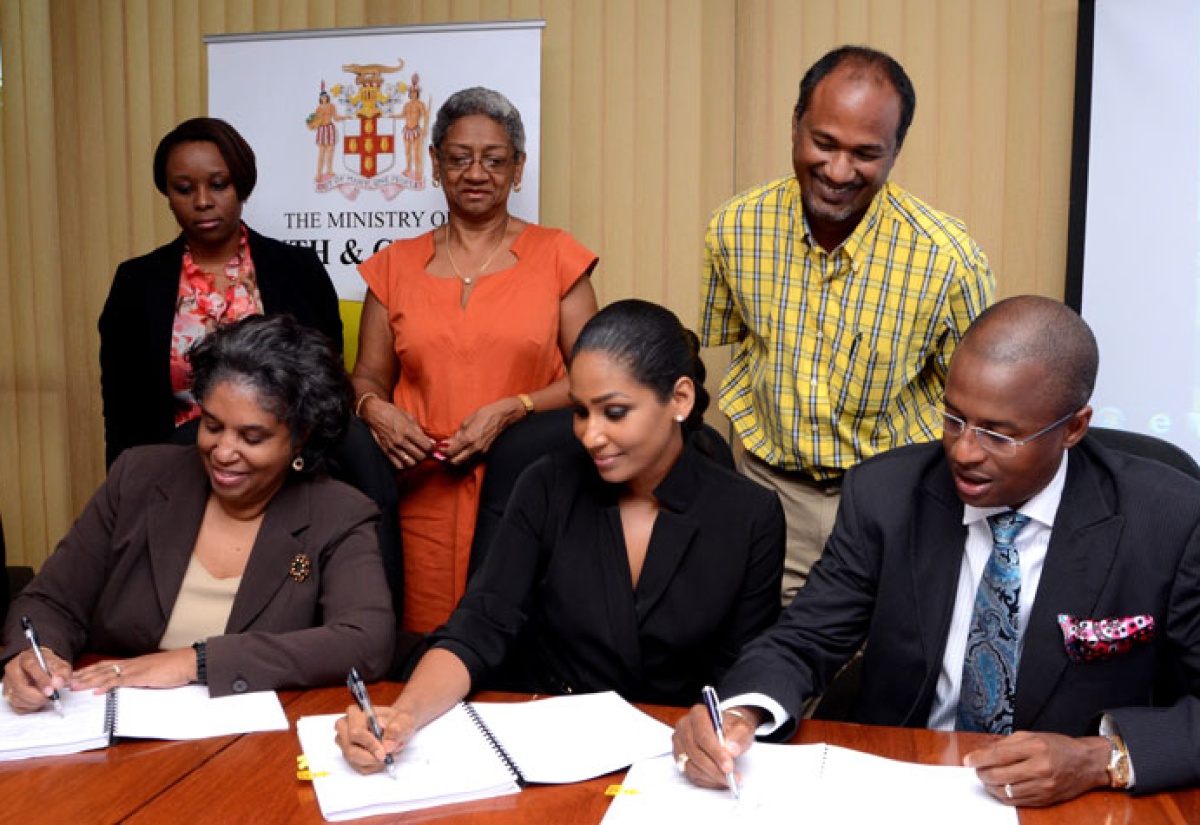 Minister of Youth and Culture, Hon. Lisa Hanna (centre); and Acting Permanent Secretary in the Ministry, Sherril O’Reggio Angus (left), affix their signatures to a contract for the construction of the Hanover Youth Information Centre, while State Minister in the Ministry of Water, Land, Environment & Climate Change and Member of Parliament for West Hanover, Ian Hayles, signs as witness. Also participating in the signing ceremony, held at the Youth and Culture Ministry, on Wednesday, April 23, are (from left): Acting Director, Youth Policy and Programme Development, Andrene Blackwin; Project Manager, Youth Development Programme, Margery Newland; and Contractor, Phillip Foote of D.R. Foote Construction Company Limited.