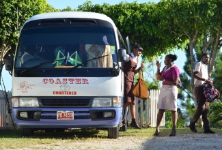 Students and staff of Holmwood Technical High School in Manchester, disembarking one of two buses contracted by the institution’s management to provide transportation services for students.
