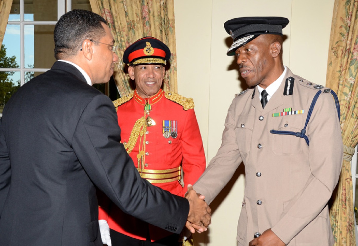 Prime Minister, the Most Hon. Andrew Holness (left), is greeted by  Police Commissioner, Dr. Carl Williams (right). Looking on is Chief of  Defence Staff (CDS), Major General Antony Anderson.