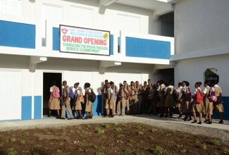 Students of the Holy Trinity High School, in Kingston,  enter one of the newly constructed classrooms which were handed over on  February 13. The new  block, which has been  named in honour of the late Archbishop Samuel Carter, will provide an additional  400 classroom spaces. The construction was done as part of the Ministry of Education’s thrust to  remove schools from the shift system.